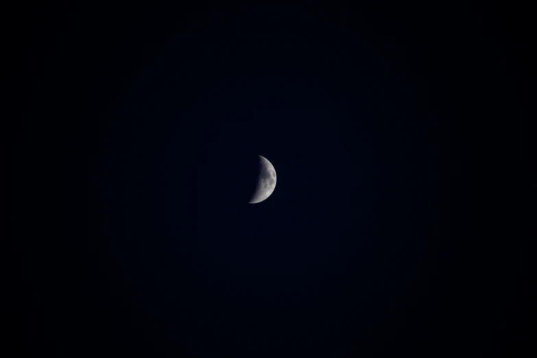 a half - moon is seen during the night sky