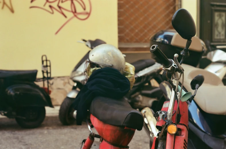 two mopeds parked next to a wall with graffiti