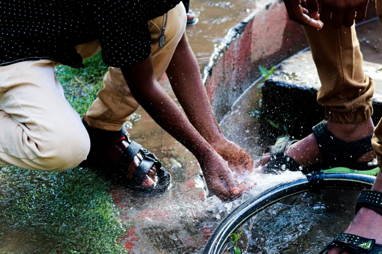 two people in sandals playing in a fountain