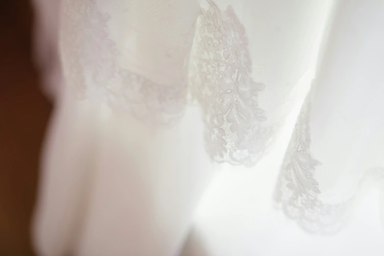 closeup of lace curtain in room with light streaming through window