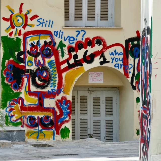 colorful building with a door and window covered by graffiti