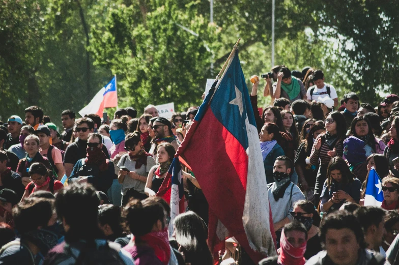large group of people with flags in the middle of an open area