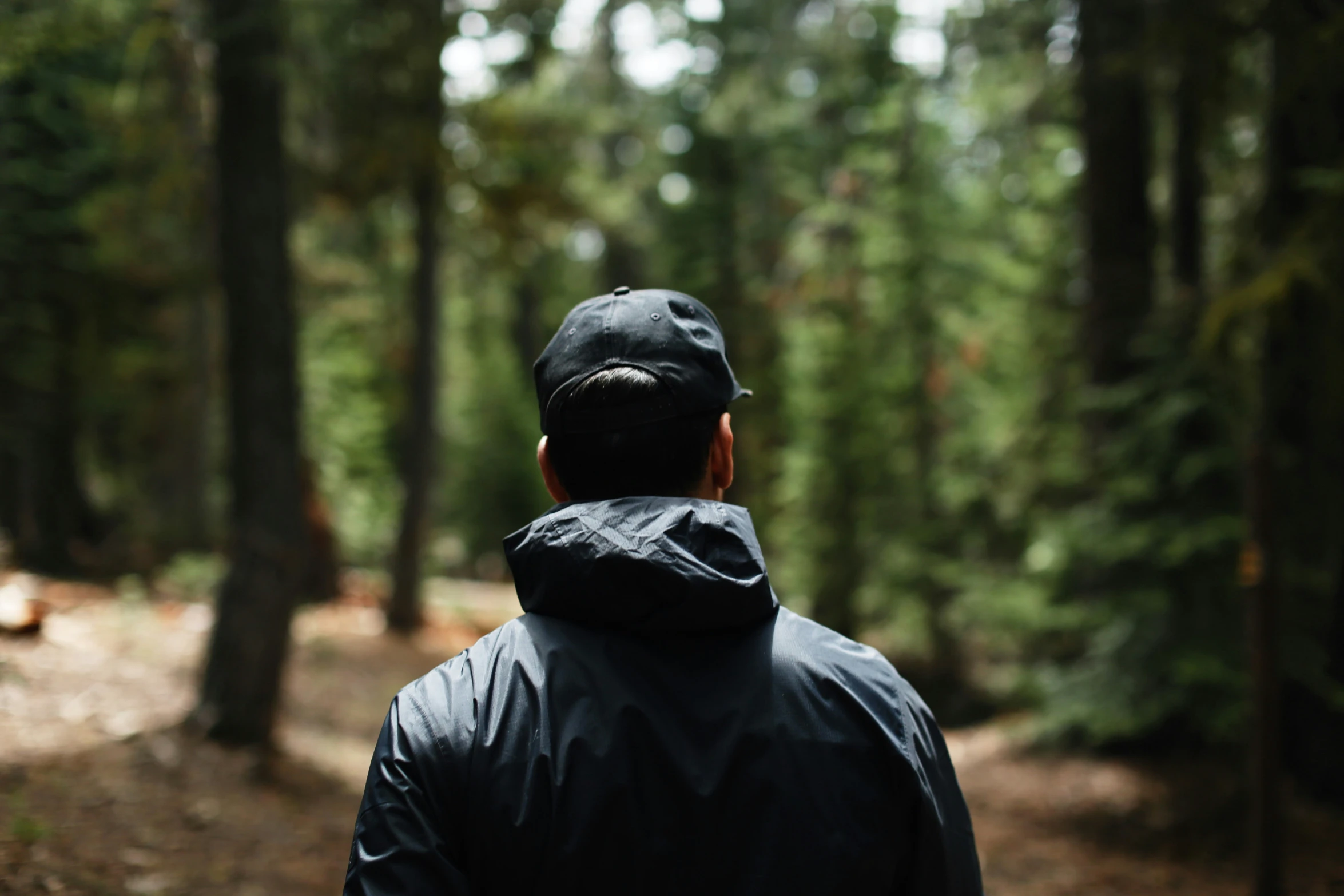 a person in the woods wearing a jacket and hat