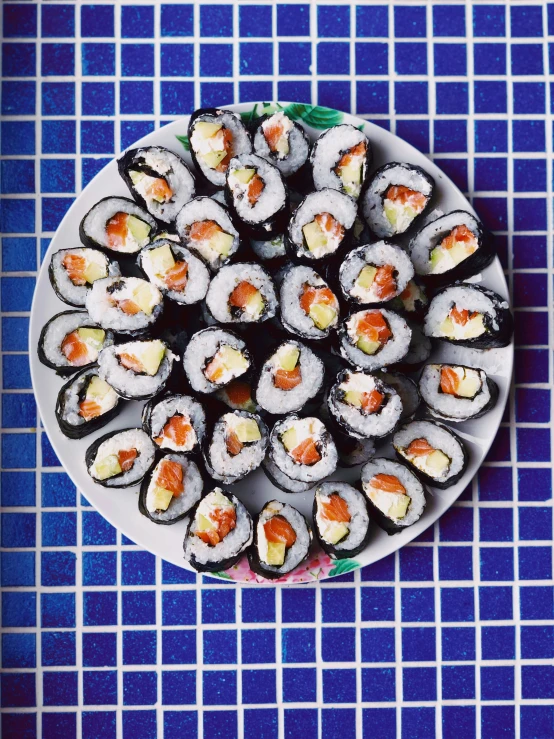 a sushi dish is made of sushi rolls with carrots on them