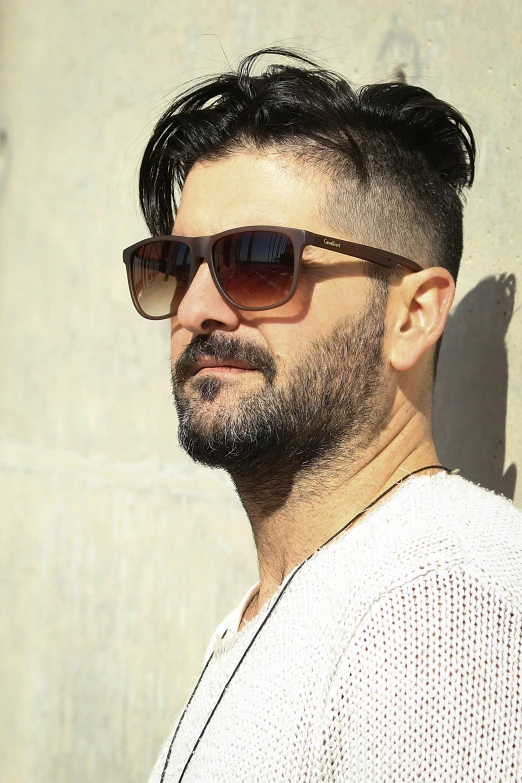 a man with a goatee and sunglasses looking ahead