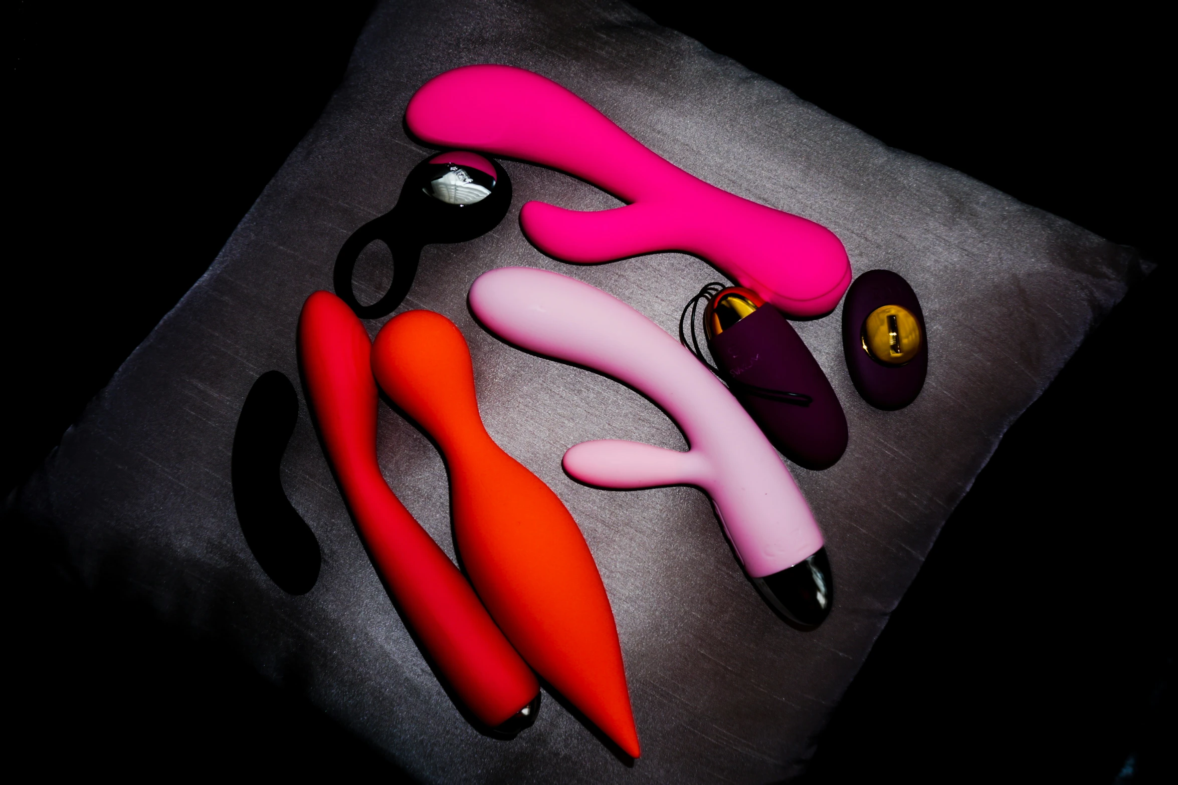 a group of pink and orange scissors on top of a pillow