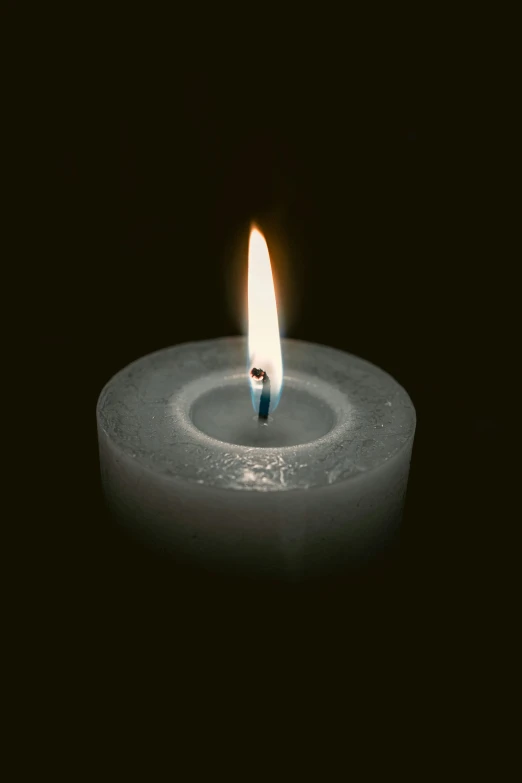 a single candle burning inside of a round