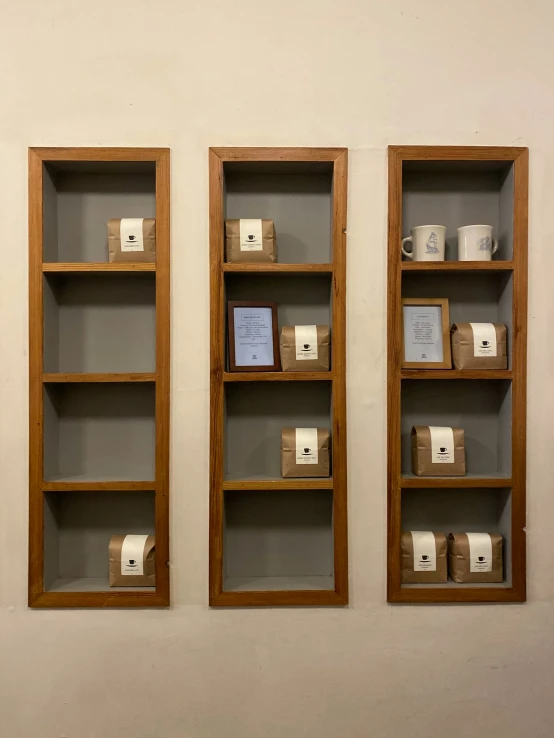 a wall is displaying two empty wooden shelves