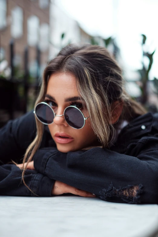 a girl with dark hair wearing a pair of round glasses