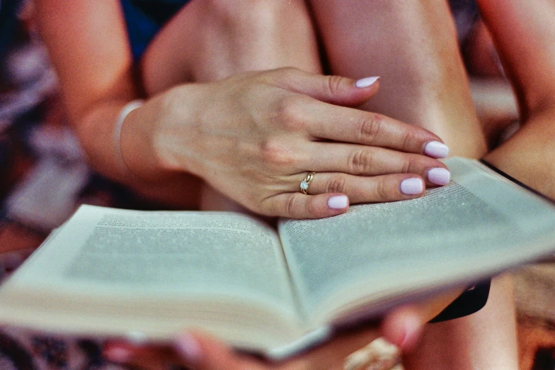a girl holding a book with her hand