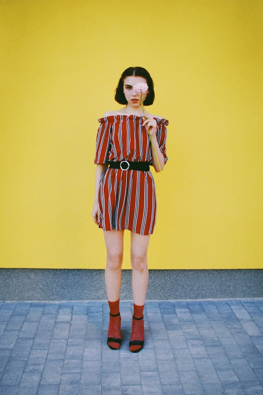 a woman with red hair in a red and black striped dress