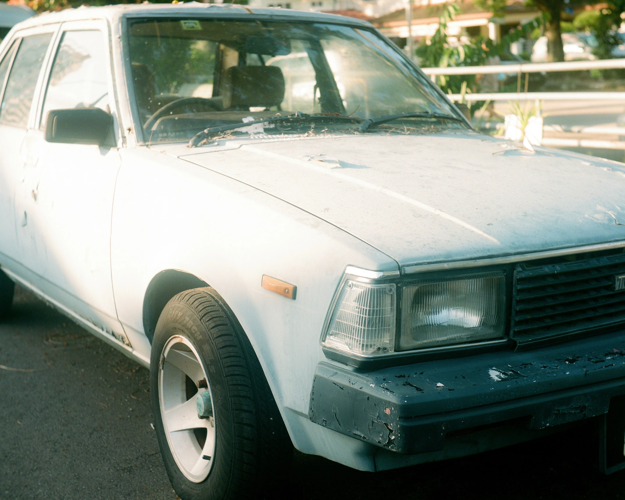 an old car sits parked near a curb