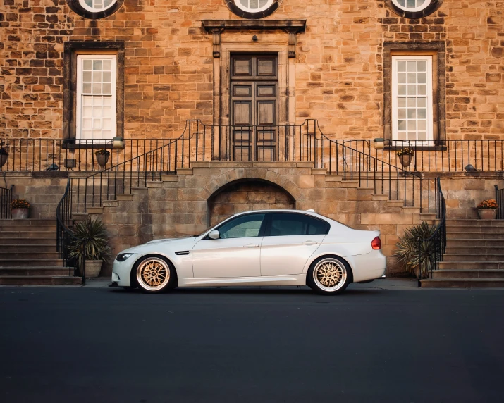 the car is parked in front of an elegant building