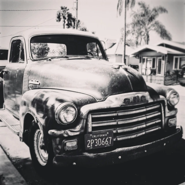 the back of an old truck parked on the side of the road