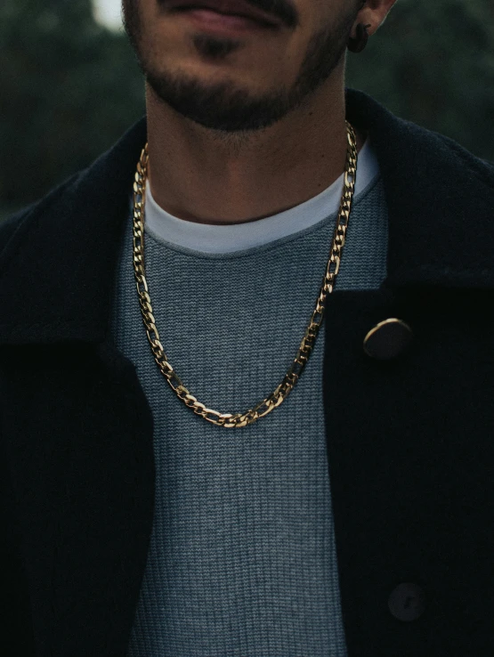 a close up of a person wearing a chain necklace