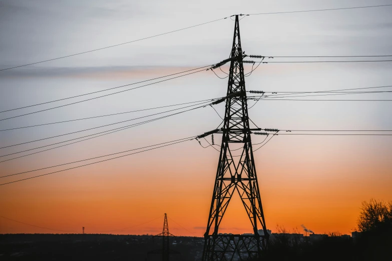 the sun is setting on an electrical line