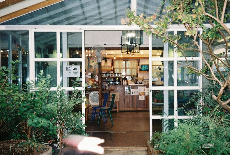 a room with chairs, tables and plants in it