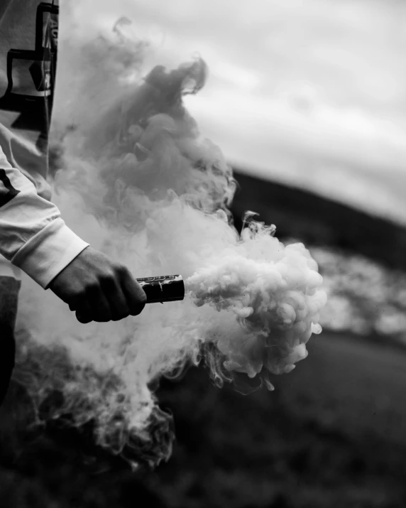 a man holding a lighter is surrounded by white smoke