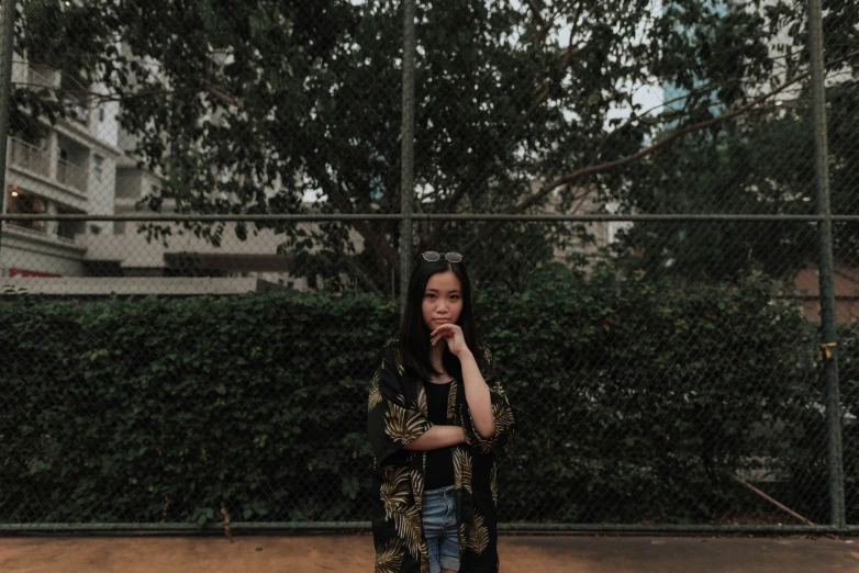 a woman standing outside with her hands to her ear