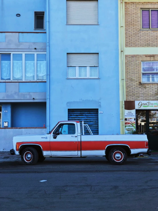 an old pickup truck is parked on the side of a road