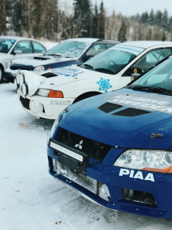 several racing cars lined up in snow on the track
