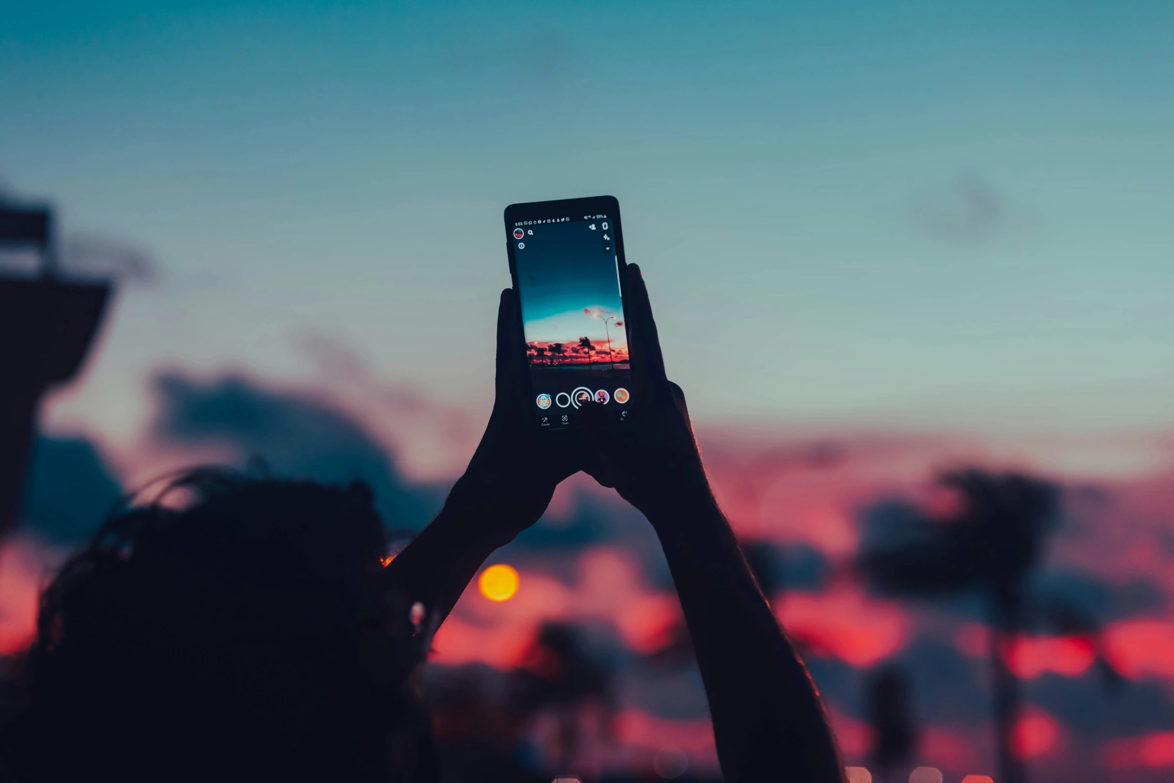 a person holding up a cell phone in the air