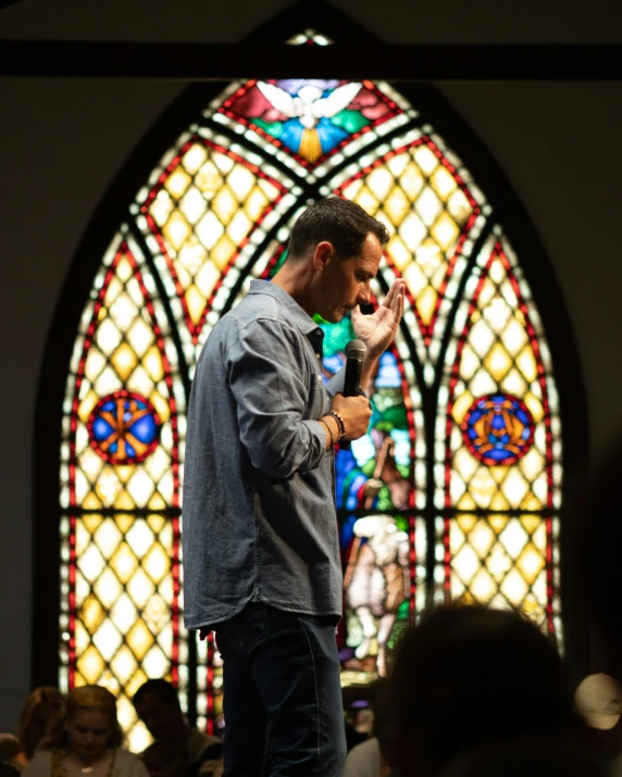 man standing in front of a stained glass window