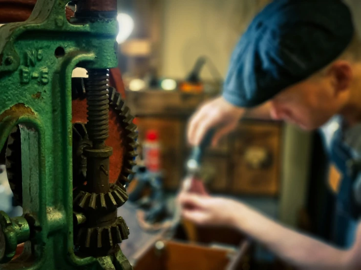 a man working with a metal object in his work space