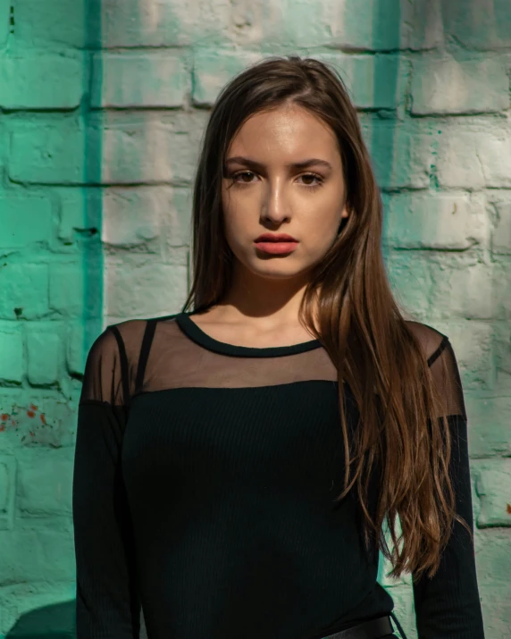 a young woman with long hair and black shirt poses for a picture