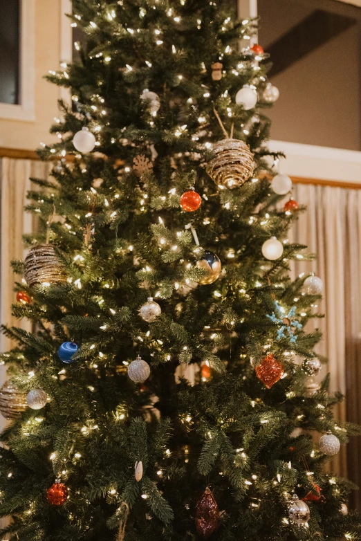 a brightly lit christmas tree with ornaments on it