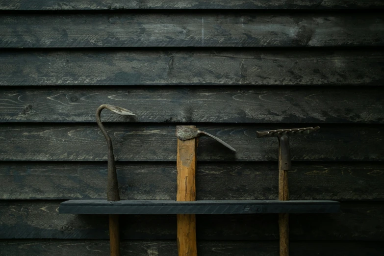 two tools are leaning against a wooden building