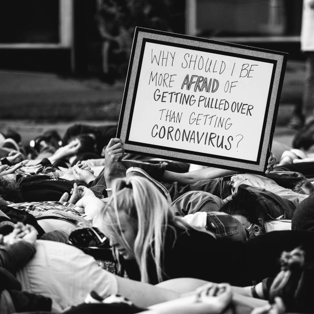 people are shown with protest signs during a demonstration in the town of corona