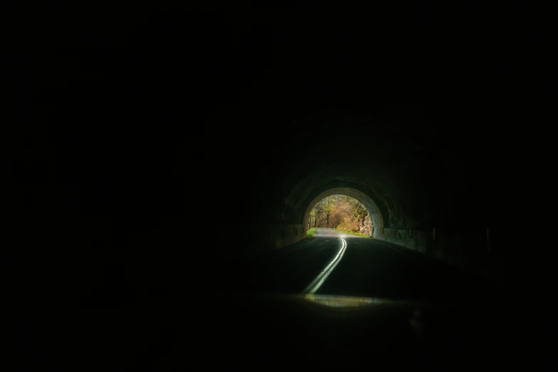 a road is shown through a dark tunnel