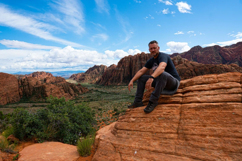 a man sitting on top of a cliff