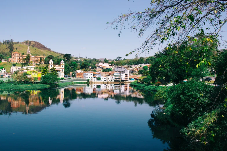 a lake next to a small village surrounded by trees