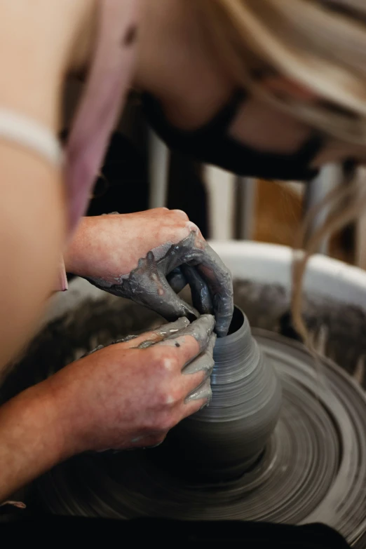 a person working on a pot in a potter's wheel