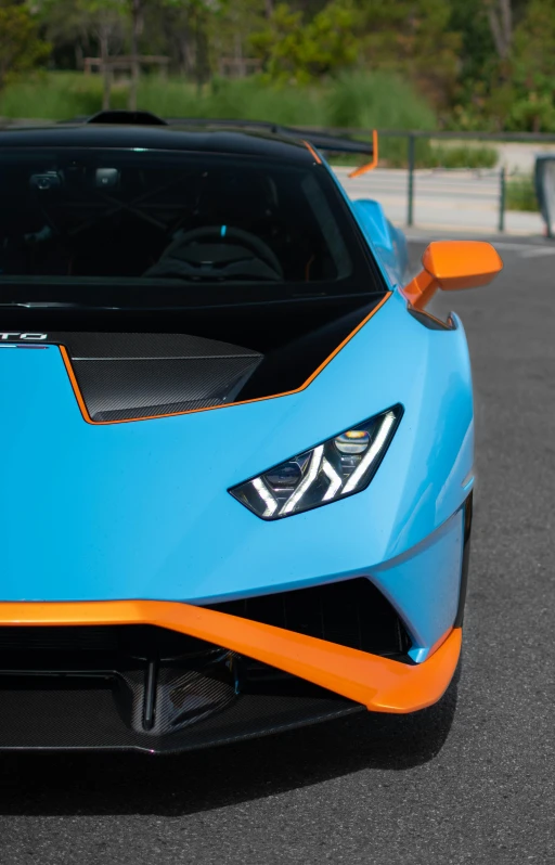 a light blue and orange sports car is sitting