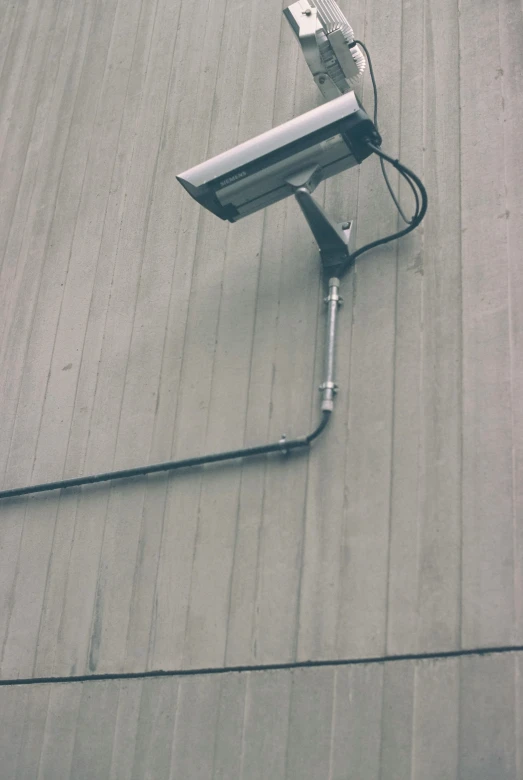 there is a camera that is attached to the side of a building