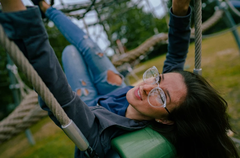 a woman lying down on a green swing