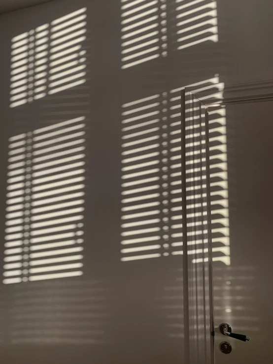 sunlight streaming through the blinds on the wall