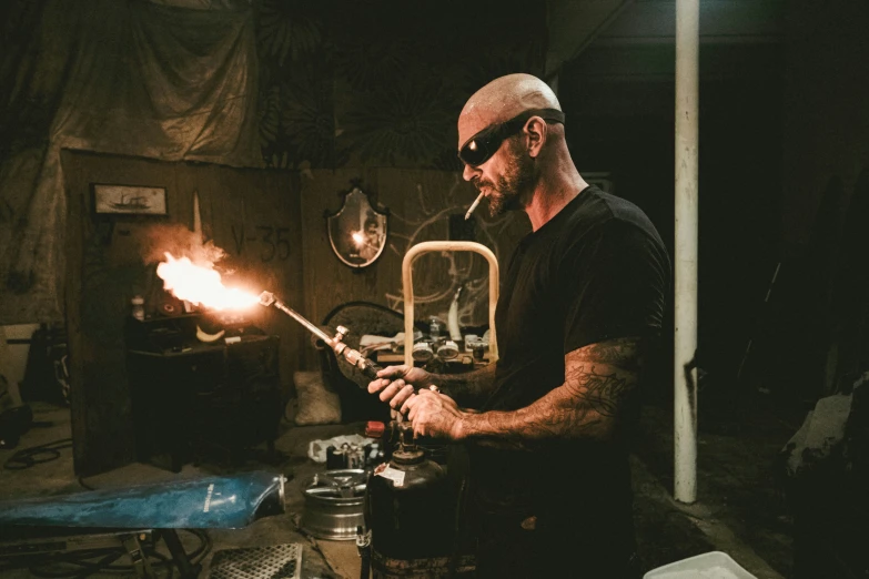 a man holding a metal bar making a small object