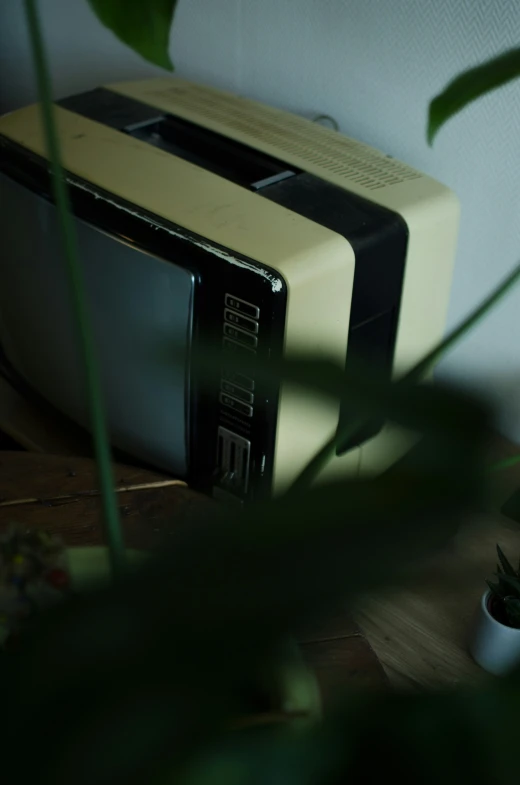 two microwaves on a table in a corner