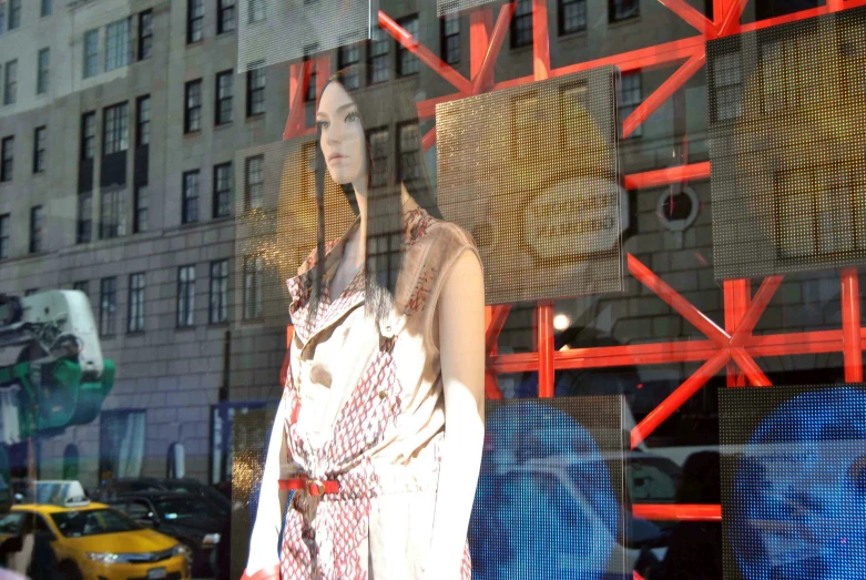 a woman's fashion display is seen through a window