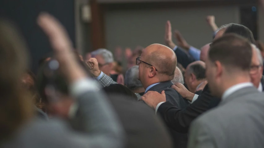 two men in suits hug and celete at a business meeting