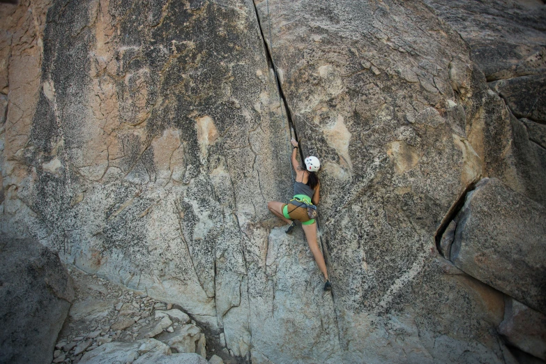a rock climber is climbing up a rocky cliff