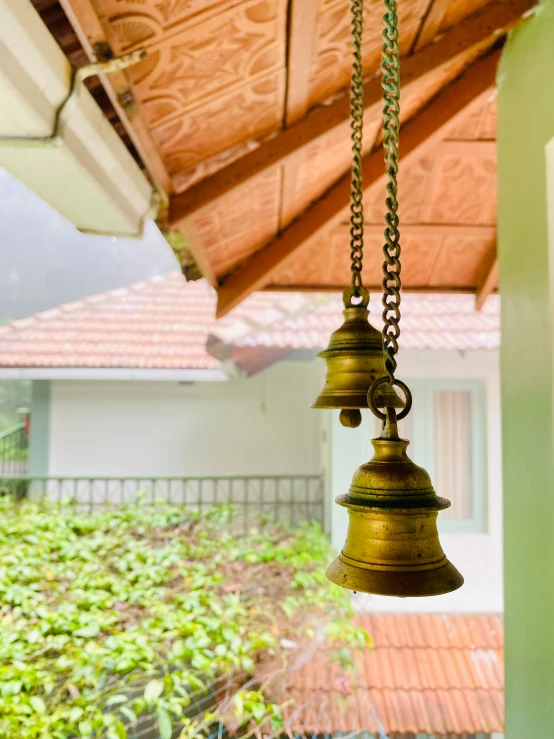 bells on the wall with green building in the background