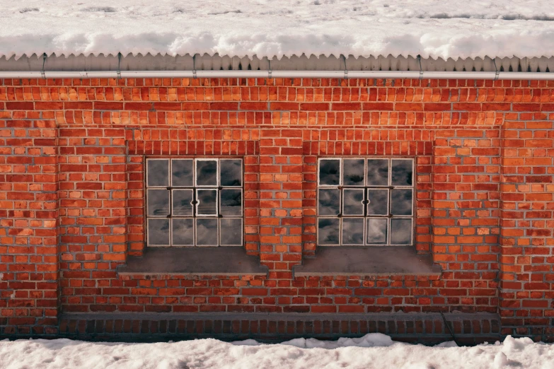 the view of two windows and snow from a ledge