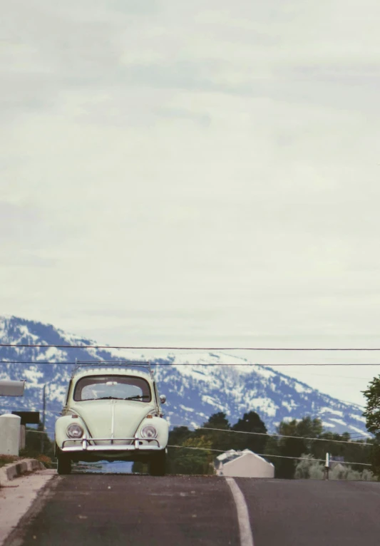 an old volkswagen is sitting on the side of the road
