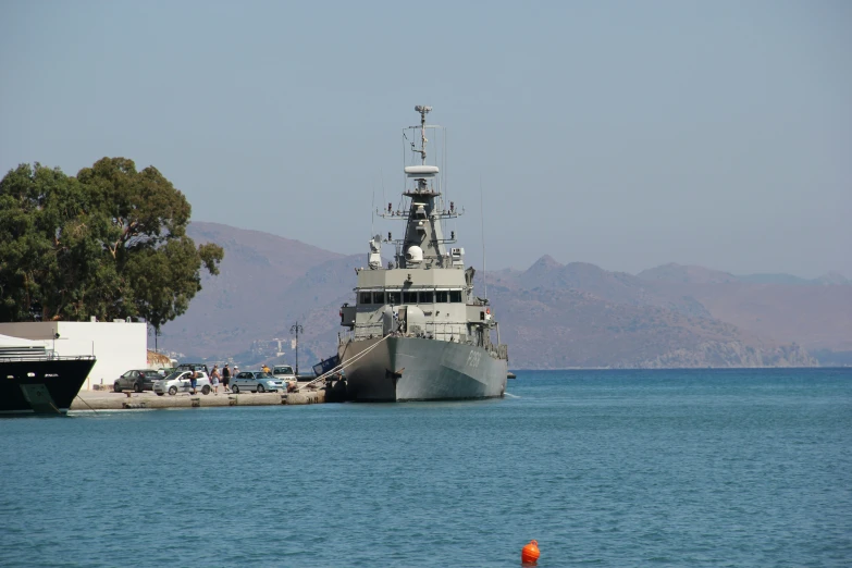 a large battleship sitting next to a dock