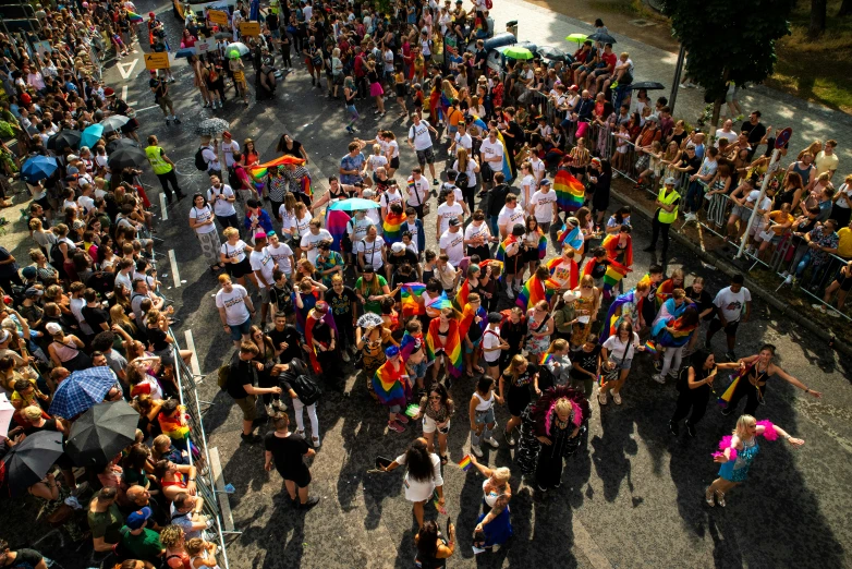 large crowd at a parade with bright rainbow colors